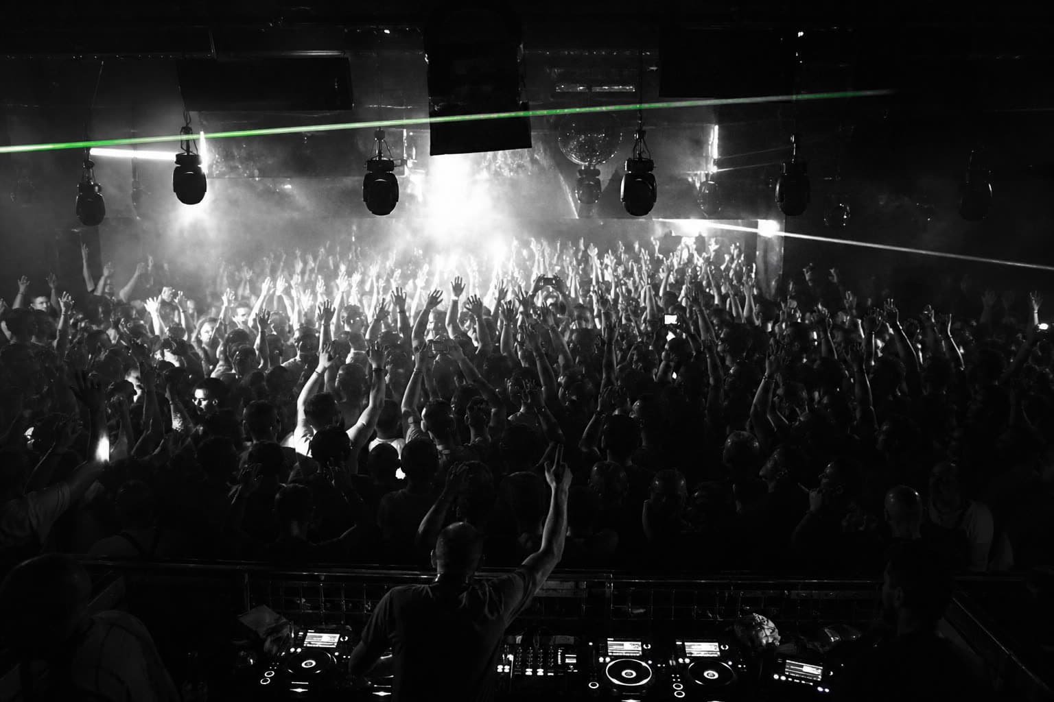 Crowd with hands in the air in a dark club